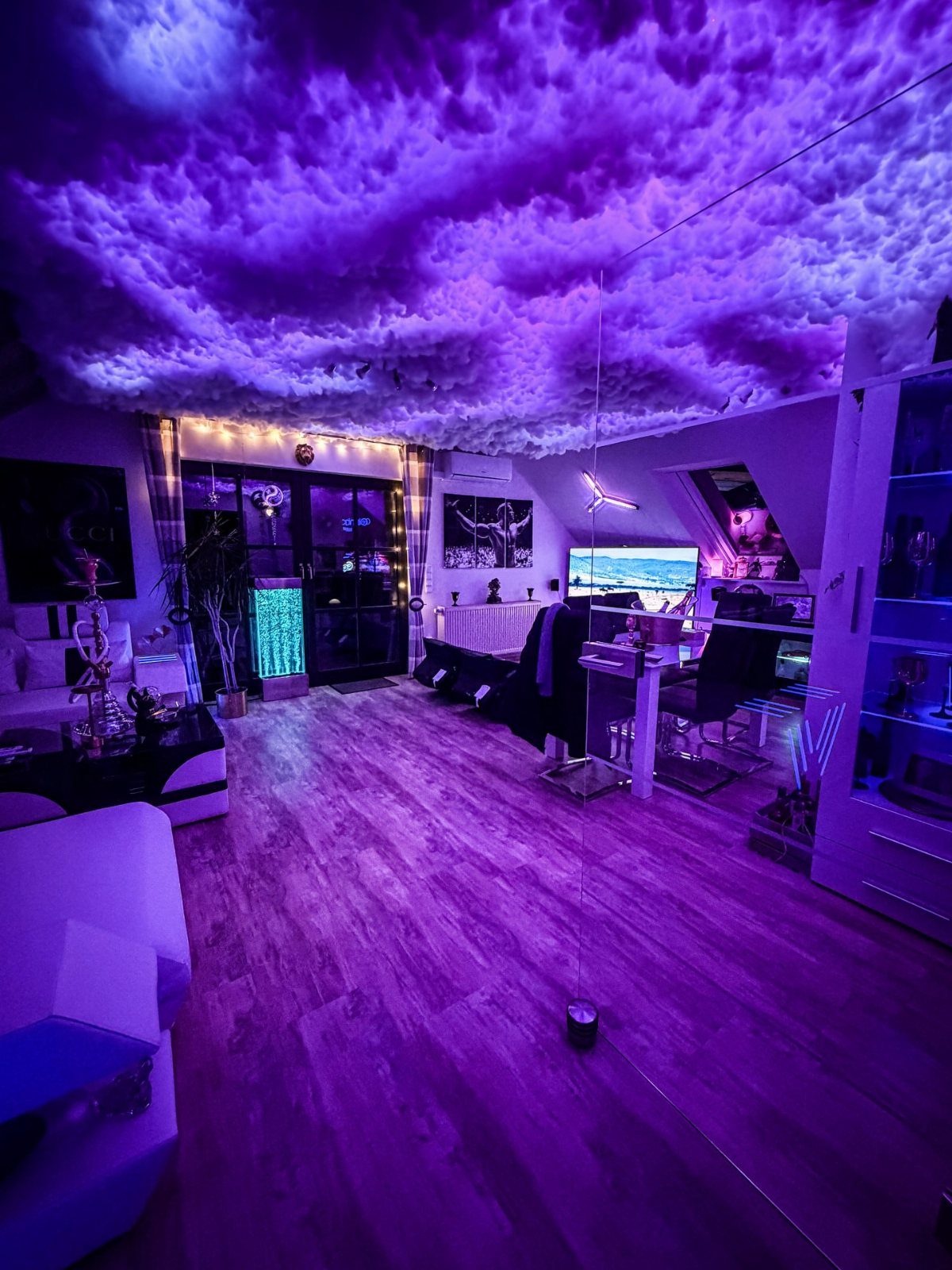 Modern room with a glowing purple cloud ceiling and ambient blue lighting.