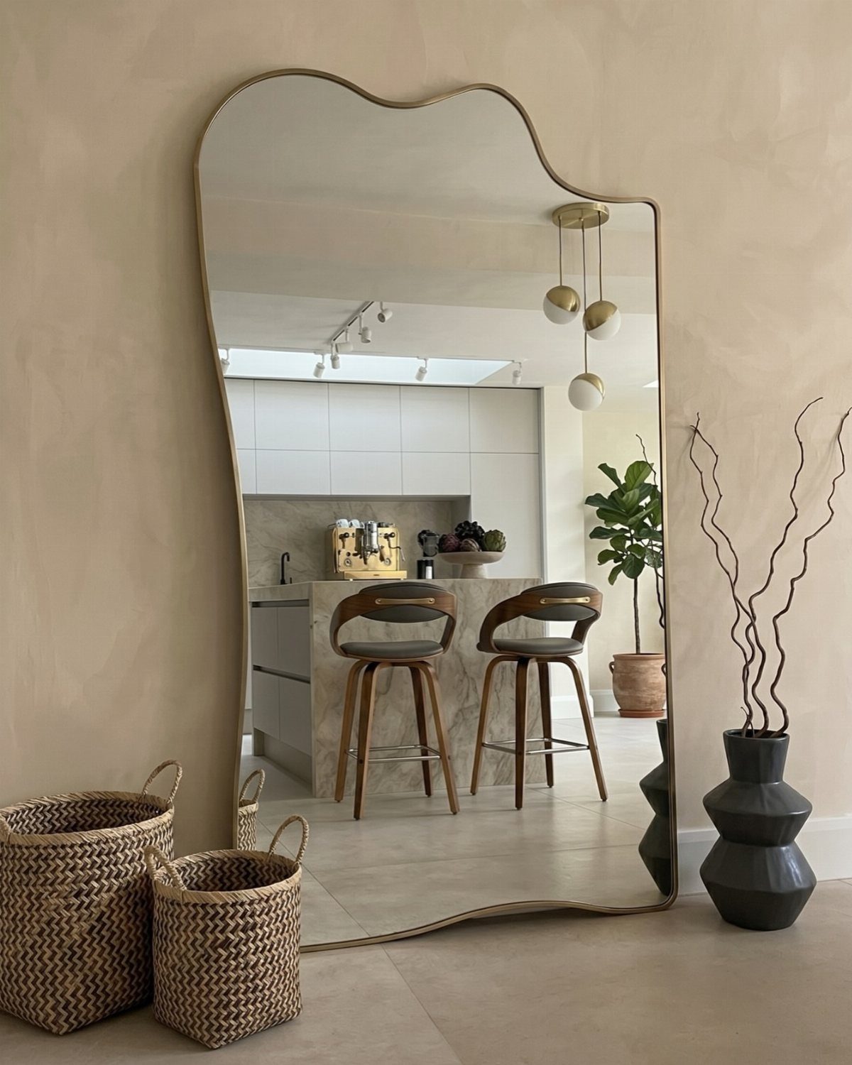 Irregularly shaped oversized floor mirror leaning against a beige wall in a modern room.
